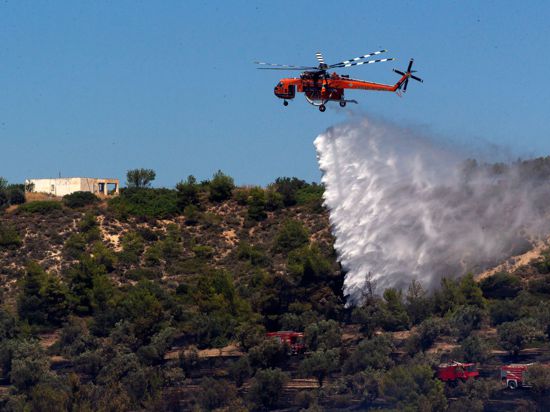 Ein Löschhubschrauber bekämpft einen Brand in Griechenland.