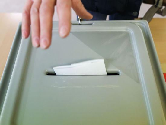 Hand wirf Zettel in Wahlurne