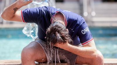 Abkühlung! Ein junger in Madrid übergießt sich mit einer Wasserflasche. Die Hitzewelle in Spanien erreicht nun auch Deutschland.