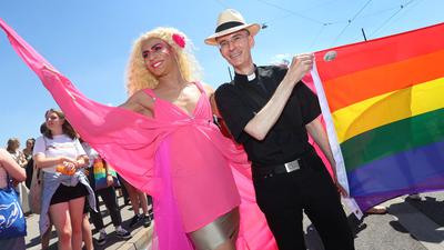 Der katholische Geistliche Wolfgang Rothe (r) nimmt an der Parade anlässlich des Christopher Street Day (CSD) in der Münchner Innenstadt teil.