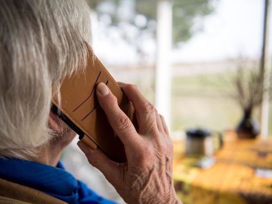 Eine alte Frau telefoniert. Telefonbetrüger überrumpeln gern mit falschen Geschichten und ergaunern viel Geld. (Symbolbild)