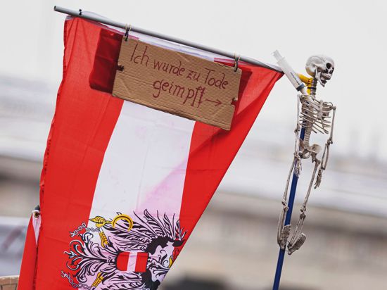 Österreichische Fahne mit der Aufschrift „Ich wurde zu Tode geimpft“ auf einem Protest gegen Corona-Maßnahmen der österreichischen Regierung in Wien. (Symbolbild)