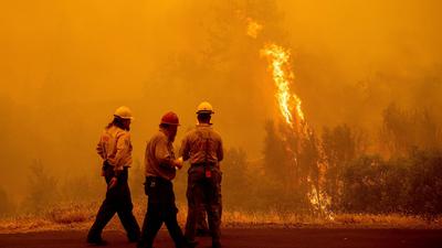 Feuerwehrleute stehen vor den Flammen des McKinney-Feuers im Klamath National Forest.