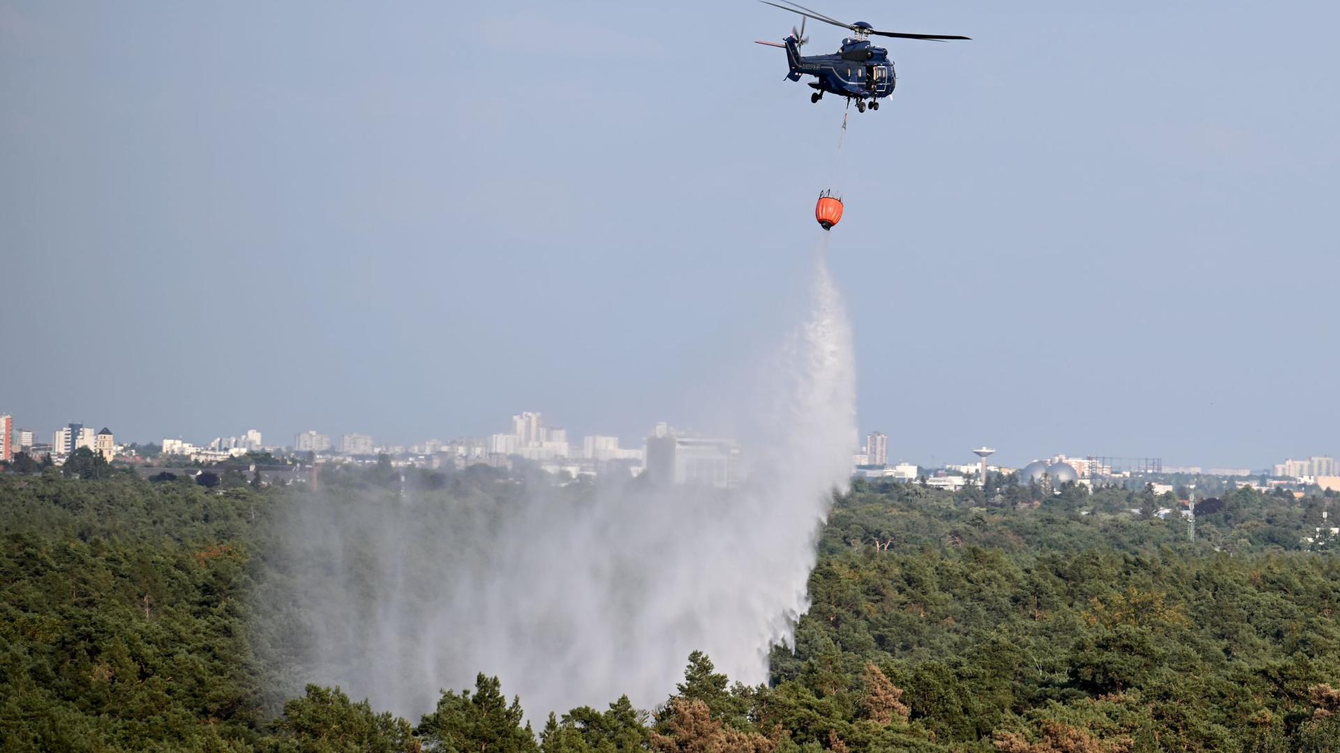Löscharbeiten aus der Luft: Ein Hubschrauber der Bundespolizei wirft Wasser über der Brandstelle im Grunewald ab.