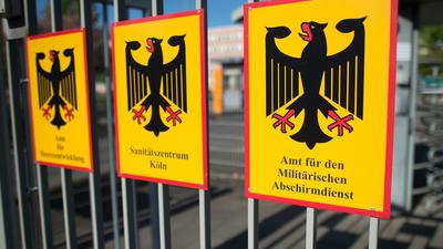 Das Schild für das Amt für den Militärischen Abschirmdienst (MAD) hängt am Zaun der Konrad-Adenauer-Kaserne in Köln. (Archivbild)