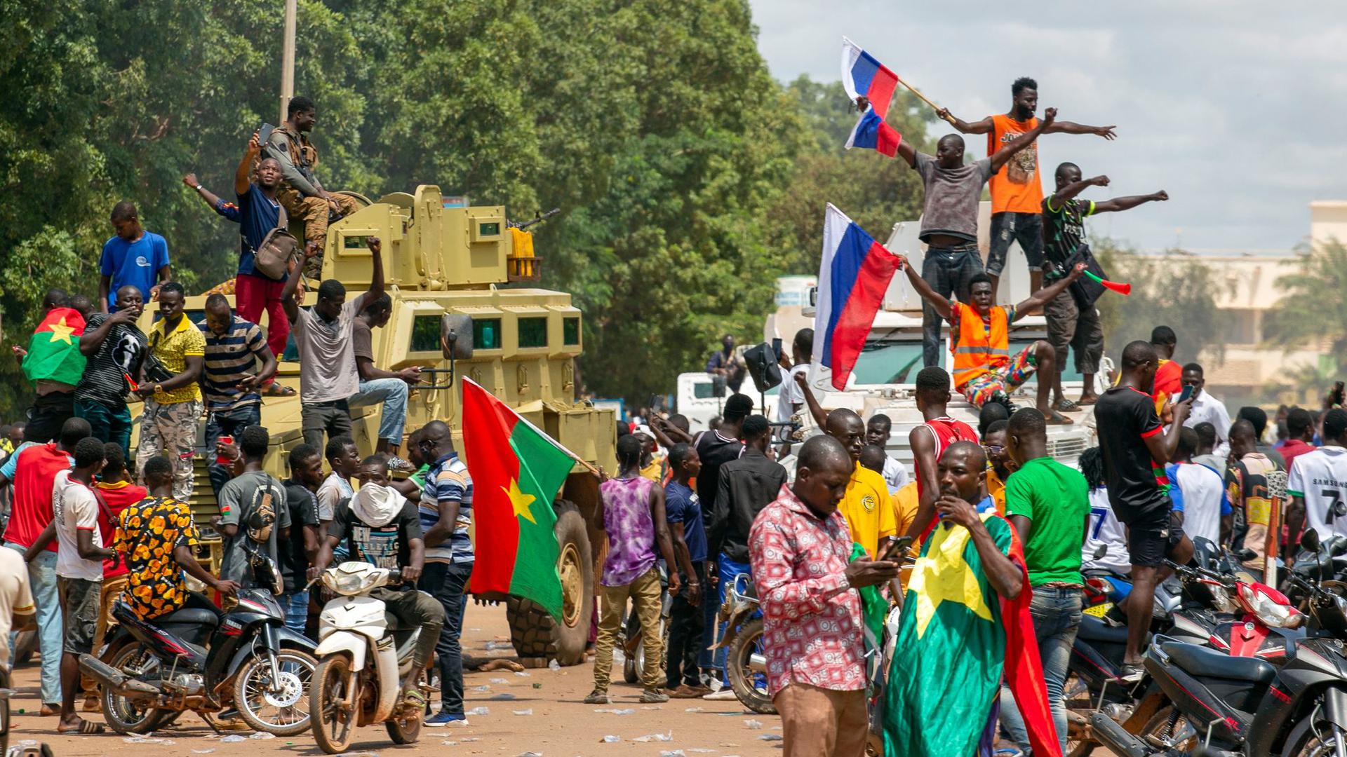 Anhänger von Hauptmann Traore jubeln mit russischen Fahnen in den Straßen von Burkina Fasos Hauptstadt Ouagadougou.