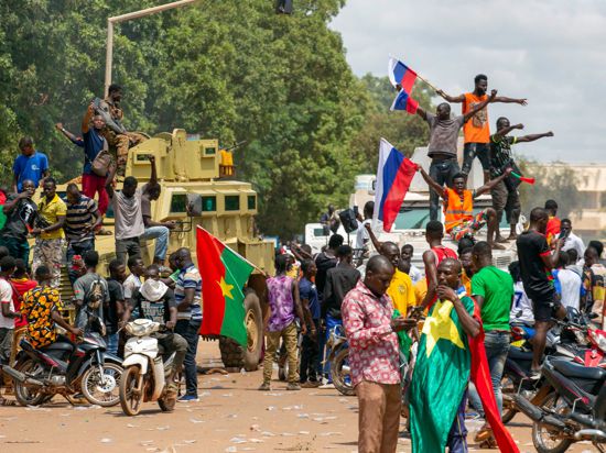 Anhänger von Hauptmann Traore jubeln mit russischen Fahnen in den Straßen von Burkina Fasos Hauptstadt Ouagadougou.