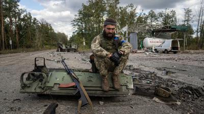 Ein ukrainischer Soldat raucht eine Zigarette, nachdem er die Leiche eines Kameraden in der kürzlich zurückeroberten Stadt Lyman gefunden und identifiziert hat.