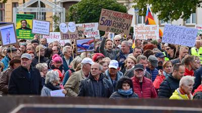 Menschen nehmen an einer Demonstration im Stadtzentrum von Frankfurt (Oder) teil – die Parolen auf den Schildern sind vielfältig.