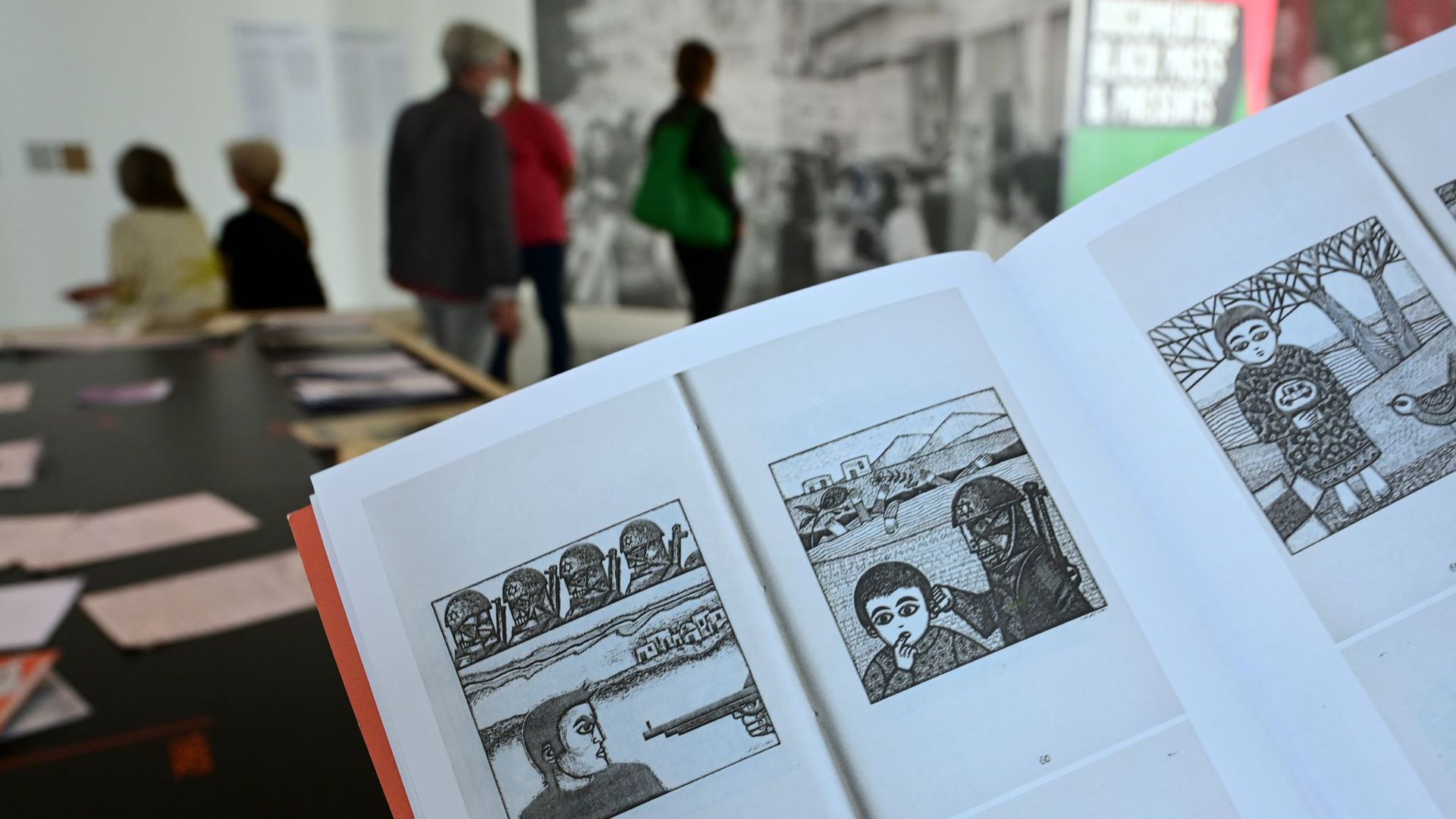 Eine Frau hält auf der documenta fifteen im Fridericianum die Broschüre mit dem Titel „Presence des Femmes“, die 1988 in Algier erschienen ist, in den Händen. Sie enthält weitere als antisemitisch kritisierte Motive.