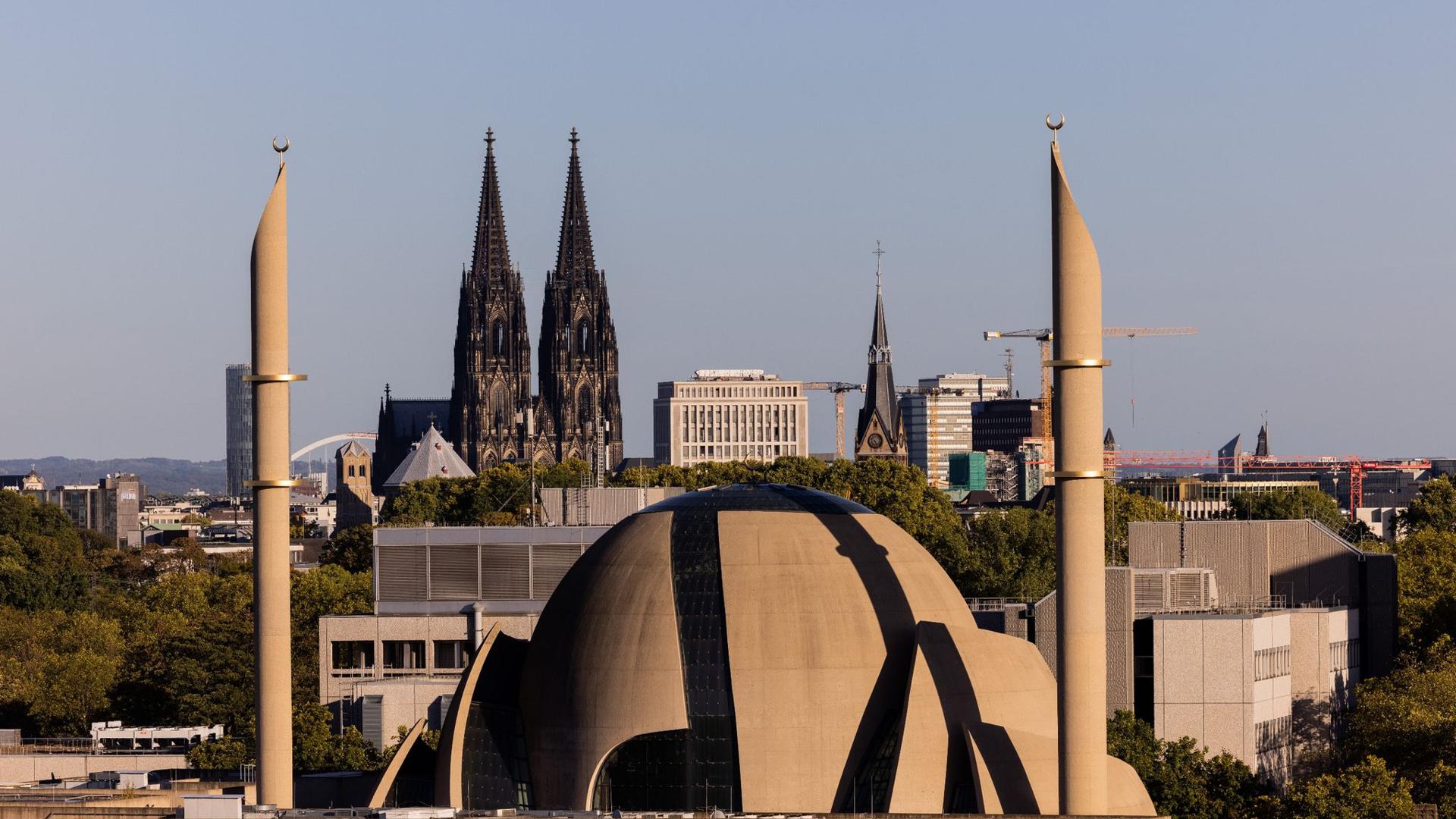 Die Minarette der Zentralmoschee der DITIB ragen vor den Türmen des Kölner Doms in den Himmel.