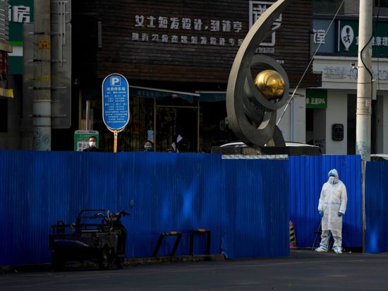 Metallbarrieren stehen um geschlossene Geschäftshäuser in Peking.