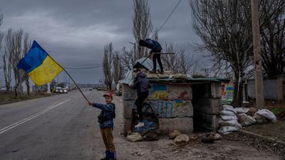 Ukrainische Kinder spielen an einem verlassenen Kontrollpunkt in Cherson.
