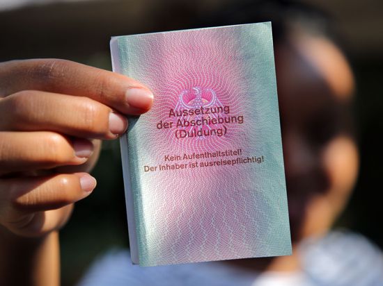 Eine junge Frau aus Afrika mit einem Ausweis für Flüchtlinge: „Aussetzung der Abschiebung (Duldung)“. Darunter ist der Vermerk: „Kein Aufenthaltstitel!“