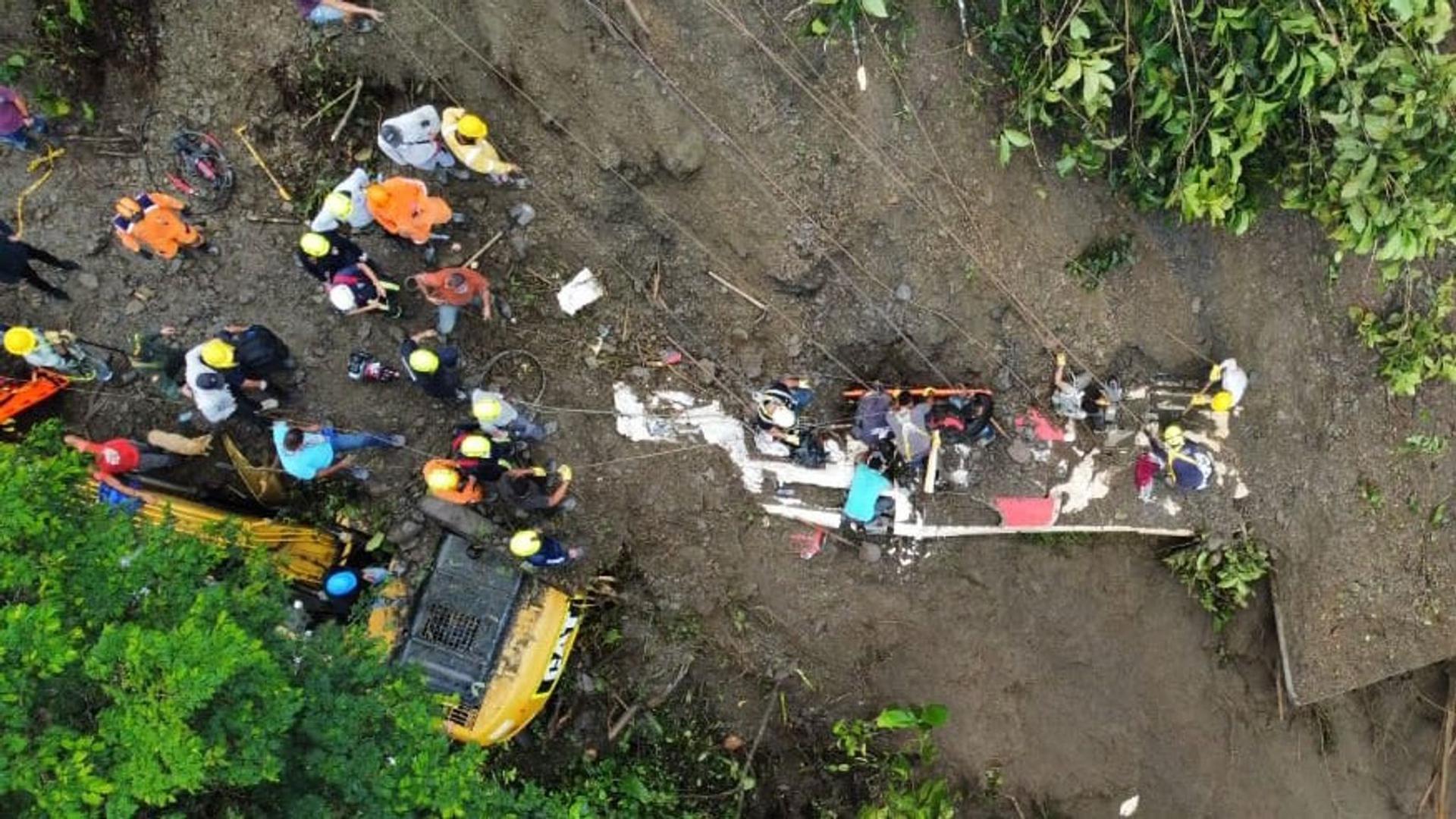 Rettungseinheiten sind im kolumbianischen Risaralda im Einsatz, nachdem Passagiere eines Busses von einem Erdrutsch verschüttet wurden.