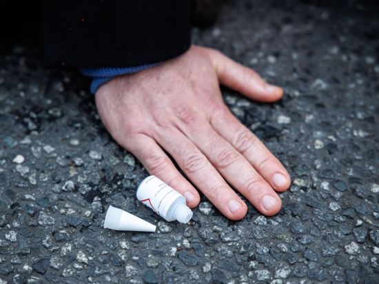 Ein Klimaaktivist hat sich am Stachus mit seiner Hand auf die Straße geklebt.