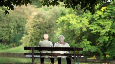 Zwei Rentner sitzen auf einer Bank.