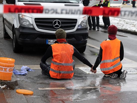 Zwei Klimaaktivisten während einer Protestaktion der Gruppe „Letzte Generation“ in München.