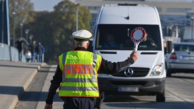 Ein Beamter der Bundespolizei stoppt den Fahrer eines Kleintransporters an einem deutsch-polnischen Grenzübergang.