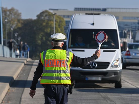 Ein Beamter der Bundespolizei stoppt den Fahrer eines Kleintransporters an einem deutsch-polnischen Grenzübergang.