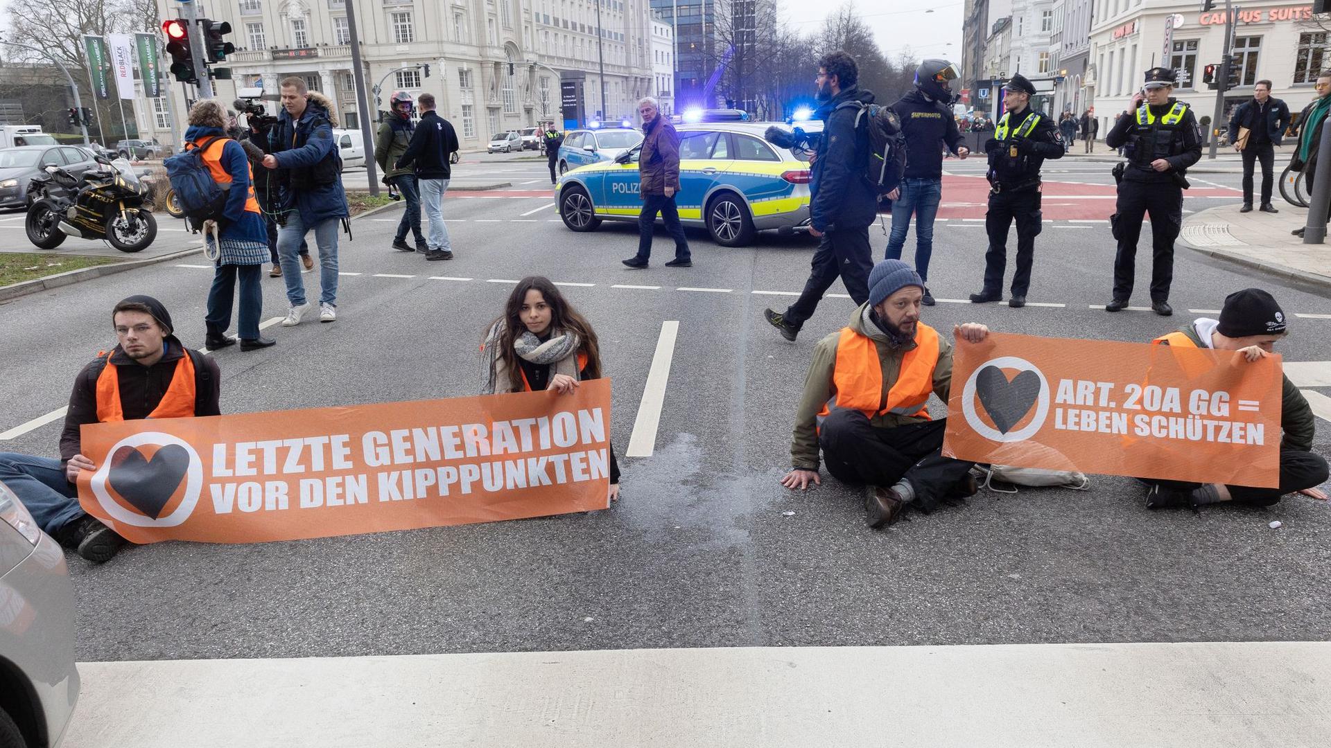 Aktivisten der Umweltgruppe „Letzte Generation“ haben sich auf dem Hamburger Gorch-Fock-Wall und wollen damit auf Klimakrise aufmerksam machen.