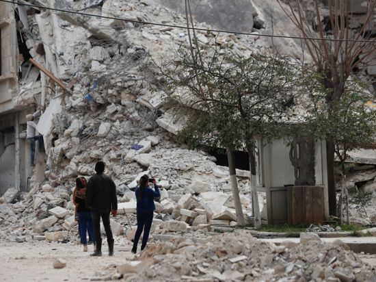 Menschen stehen vor den Trümmern eines Gebäudes, das bei dem jüngsten Erdbeben in Aleppo zerstört wurde.
