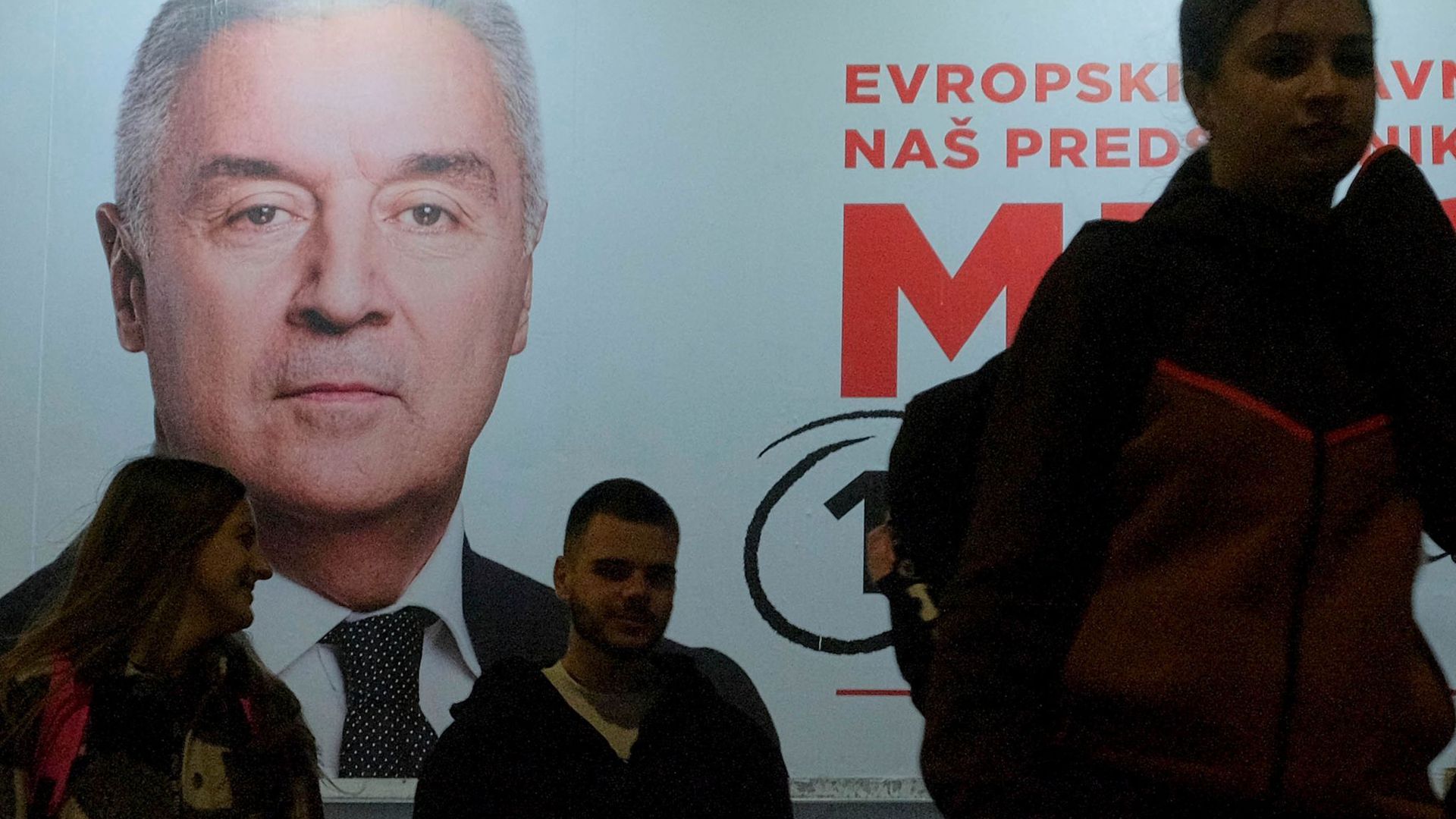 Der Wahlkampf ist zu Ende: Menschen gehen an einem Plakat des pro-westlichen Amtsinhabers Milo Djukanovic vorbei.