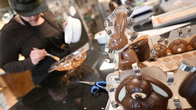 Eine Konditorin „schminkt“ in der Chocolaterie Amelie in Garmisch-Partenkirchen eine Osterei-Form.