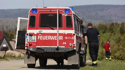 Einsatzkräfte der Feuerwehr beobachten vom niedersächsischen Wurmberg aus das Waldbrandgebiet am Brocken.