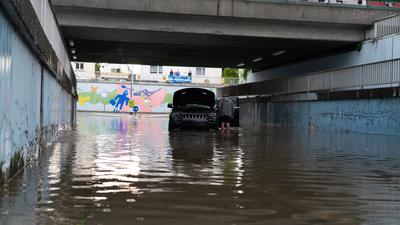Ein Auto steht in einer überschwemmten Unterführung in Darmstadt. Heftige Gewitter mit Starkregen haben vor allem in Südhessen Schäden angerichtet.