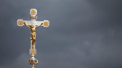 Dunkle Wolken über einem Kruzifix: Immer mehr Menschen nehmen Abstand von der Katholischen Kirche.