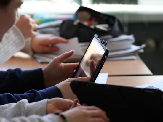 Schüler einer Grundschule in Berlin lösen im Unterricht an Tablets eine Aufgabe.