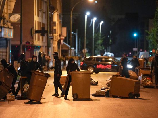 Protestierende blockieren eine Straße mit Mülleimern in Colombes, außerhalb von Paris.
