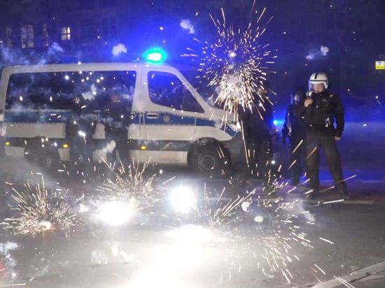 Polizeibeamte stehen in der Silvesternacht in Berlin hinter explodierendem Feuerwerk (Symbolbild). „Auch in Deutschland sind an bestimmten Orten solche Krawallexzesse denkbar“, sagt Polizei-Gewerkschafter Jochen Kopelke.