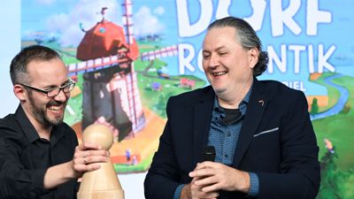 Die Spieleentwickler Lukas Zach und Michael Palm freuen sich über die Wahl ihres Spiels „Dorfromantik: Das Brettspiel“ zum „Spiel des Jahres 2023“.