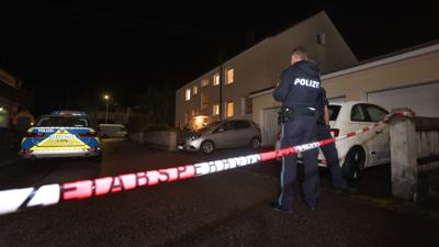 Polizisten am Tatort vor dem Haus in Langweid, in dem drei Menschen erschossen wurden.