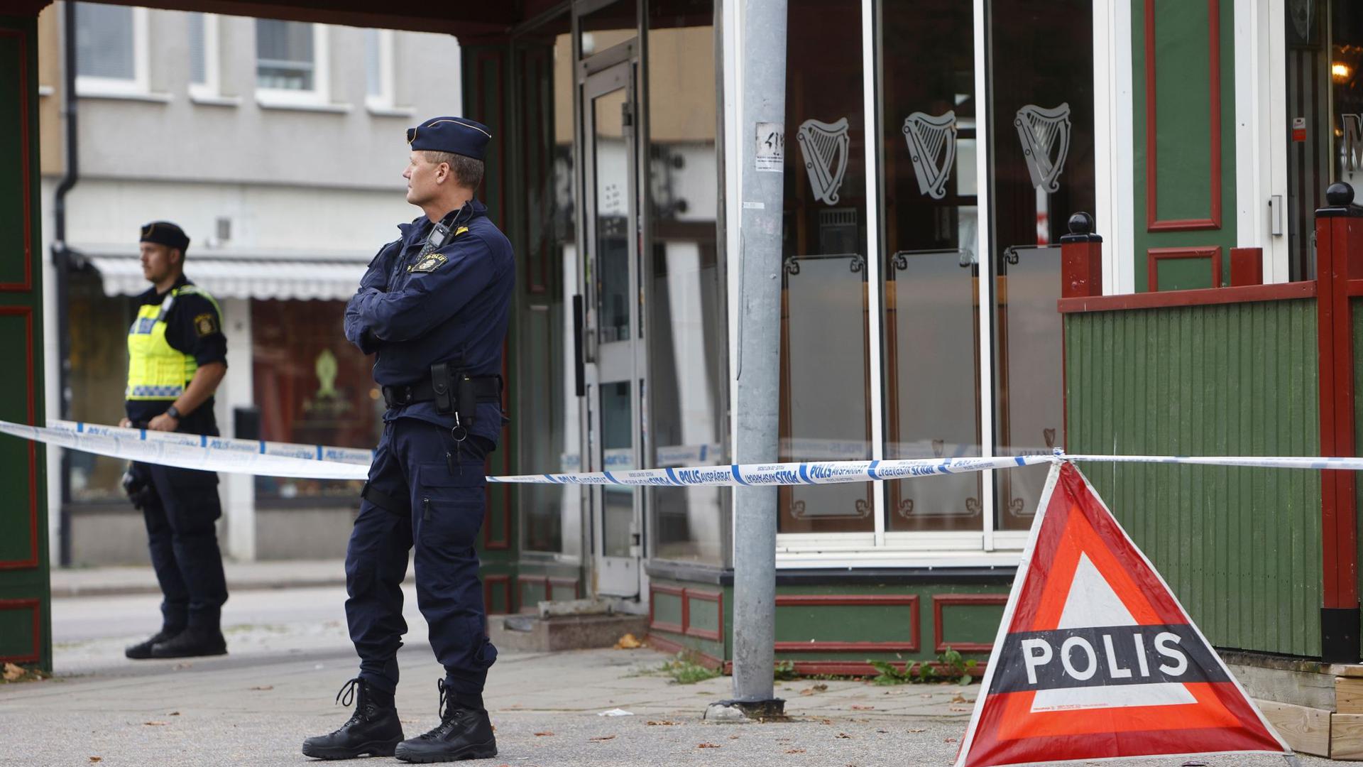 Polizisten stehen vor der Kneipe in Sandviken, in der zwei Menschen starben und zwei weitere verletzt wurden.