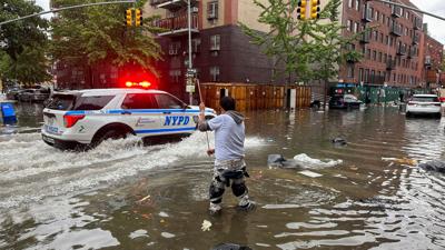 Ein Mann versucht im Stadtbezirk Brooklyn,  einen Abfluss im Hochwasser zu reinigen. Inzwischen ist das Wasser wieder versickert.