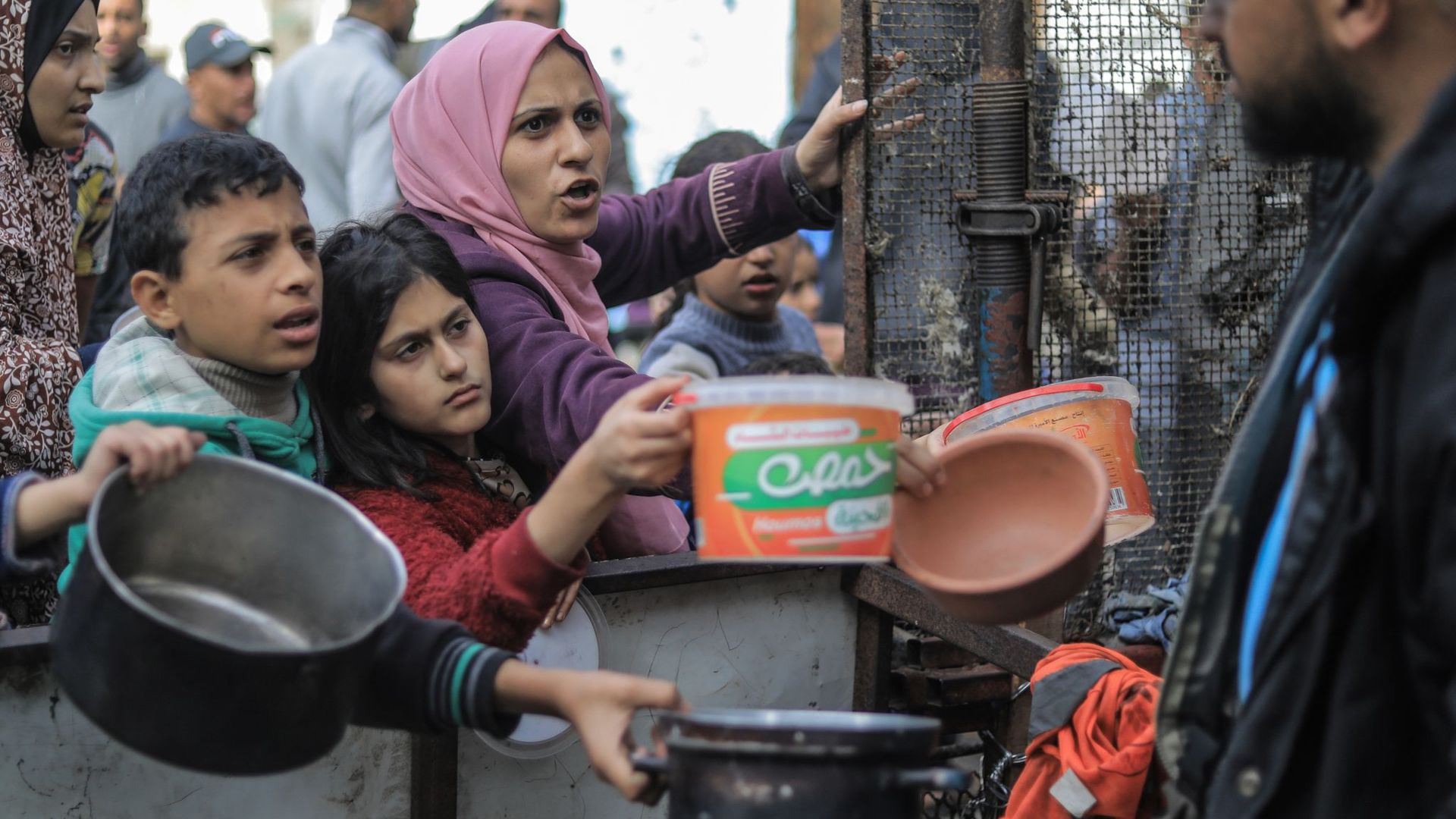 Menschen bitten an einer Essensausgabe in Rafah um Lebensmittel.