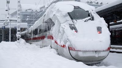 Ein ICE der Deutschen Bahn (DB) steht auf einem verschneiten Gleis.