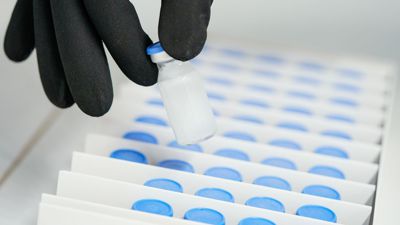 Ein Mitarbeiter hält im Werk der Roche Diagnostics GmbH eine Phiole mit dem Wirkstoff des Produkts Elevidys zur Therapie der Duchenne Muskeldystrophie in der Hand.