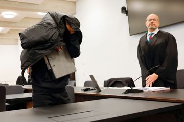 Der ehemalige Security-Mann bedeckt im Gerichtsaal seinen Kopf mit einer Jacke.