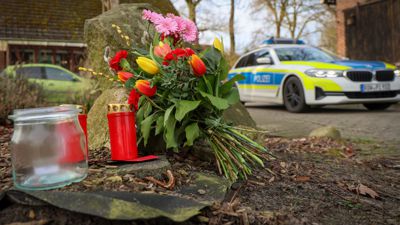 Blumen und Kerzen stehen vor einem Haus in Westervesede in der Gemeinde Scheeßel, in dem ein Mann zwei Personen erschossen haben soll.