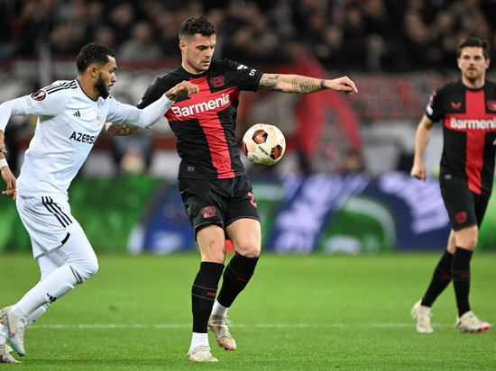Leverkusens Granit Xhaka (M) und Agdams Juninho kämpfen um den Ball.