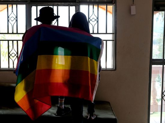Ein Paar mit einer Pride-Fahne: Die rechtliche Situation offen queerer Menschen ist nicht nur in Uganda schwierig.