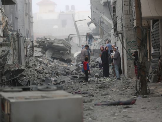 Menschen versammeln sich auf den Trümmern eines zerstörten Gebäudes nach einem Luftangriff im Flüchtlingslager Maghazi im Zentrum des Gazastreifens.