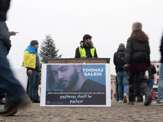 Protestaktion gegen Irans Staatsführung auf dem Pariser Platz in Berlin. Auf dem Plakat ist der Rapper Salehi zu sehen.