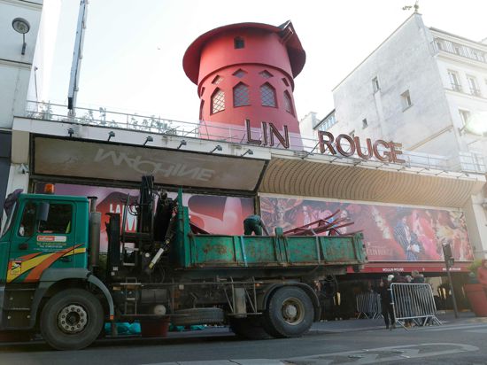 Arbeiter sichern den Bereich vor dem Kabarett, nachdem die Flügel des Windrads des „Moulin Rouge“ in der Nacht abgestürzt sind.