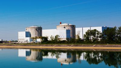 Die beiden Reaktorgebäude des Kernkraftwerk (AKW) Fessenheim und eine anliegende Halle sind aus der Entfernung im Rheintal zu sehen.