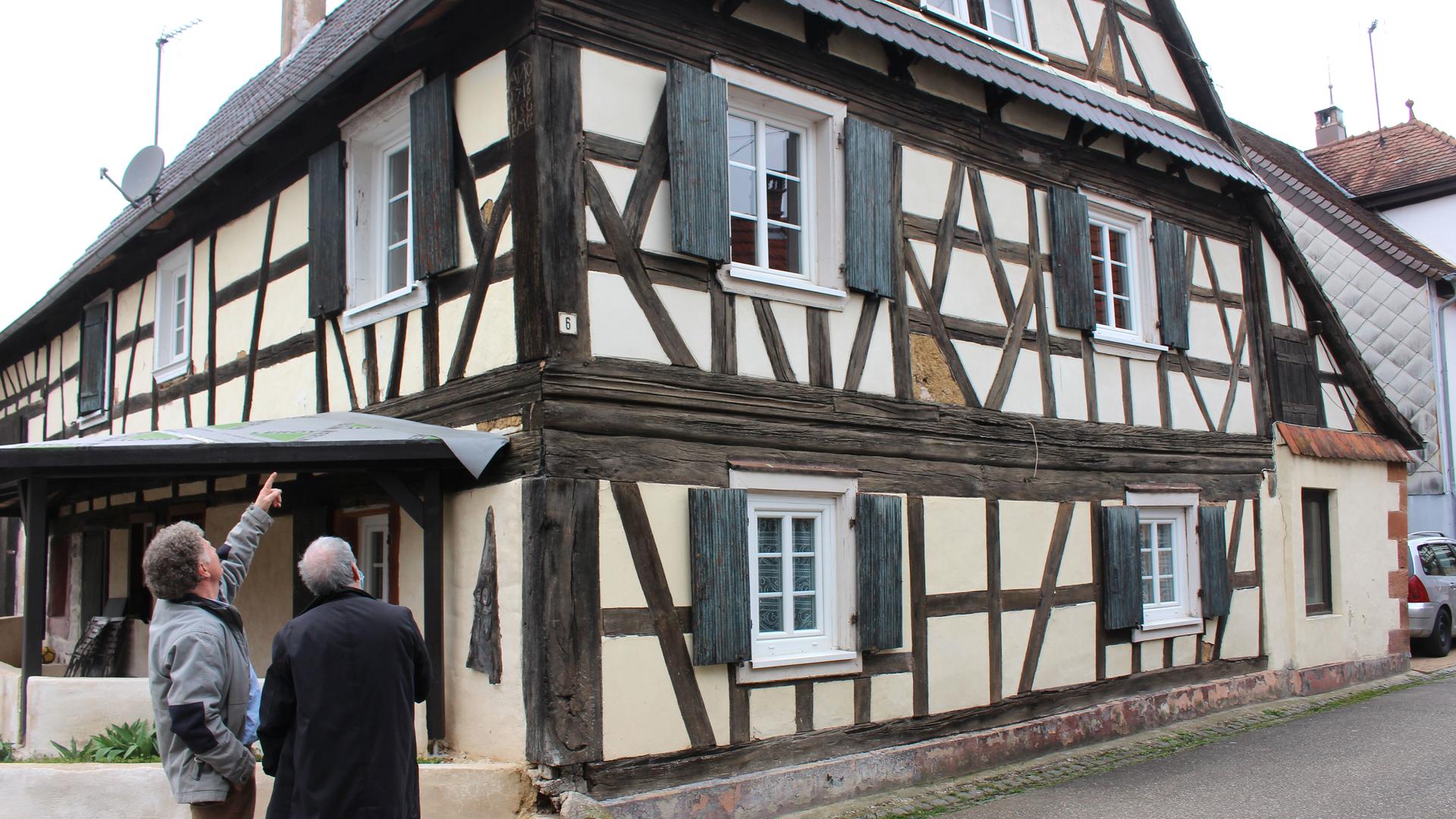 Ortsbegehung in Lembach: Denis Elbel (li.) und Charles Schlosser kämpfen für den Erhalt der Fachwerkhäuser, hier das älteste Haus des Dorfes von Mitte des 18. Jahrhunderts.